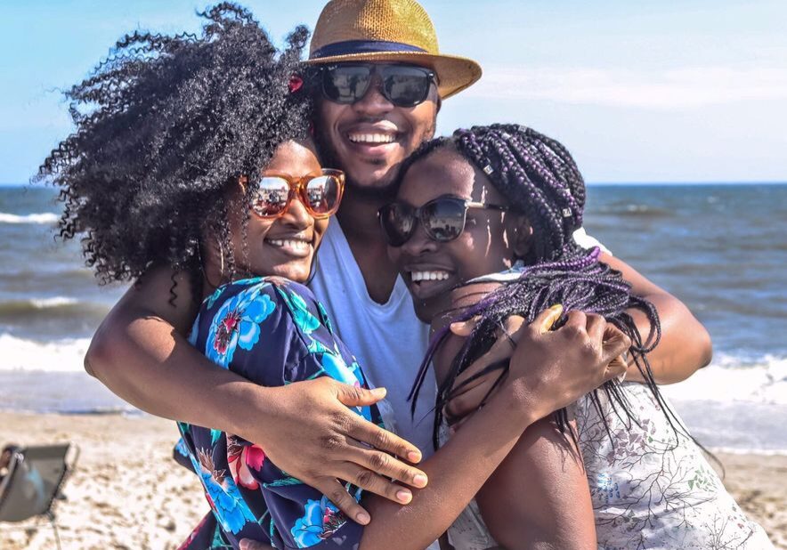 pexels-photo-936018-936018 Three friends enjoying a sunny day at the beach, embracing with smiles.